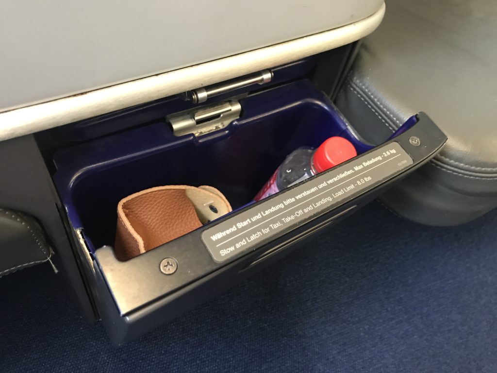 a seat with a bottle and a wallet inside