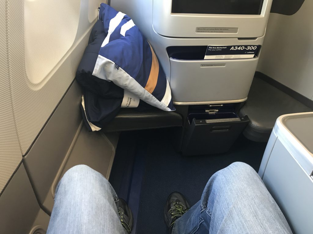 a person's legs in jeans and shoes on a seat