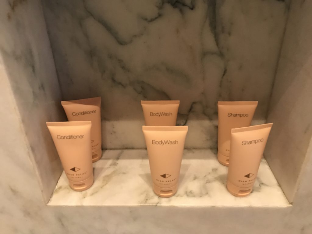 a group of cream colored containers on a marble shelf