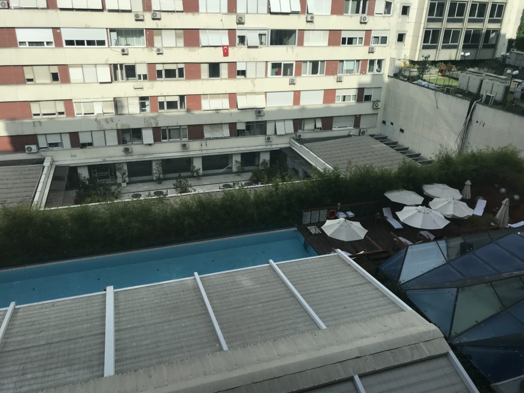 a pool and umbrellas by a building
