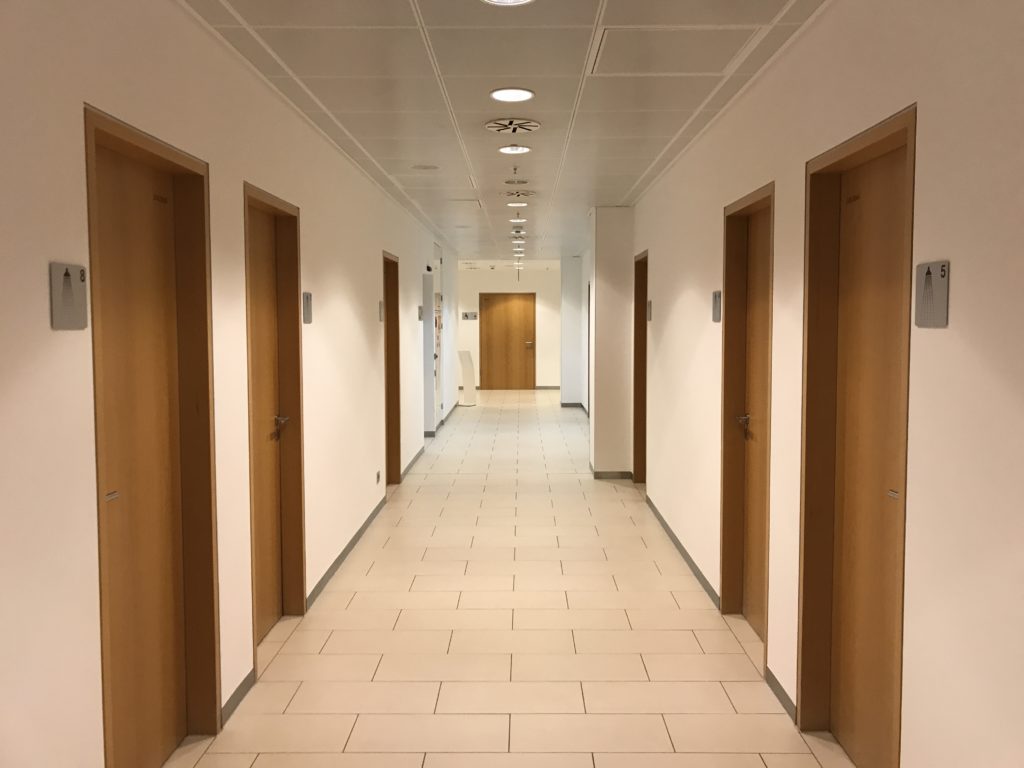 a hallway with doors and a tile floor