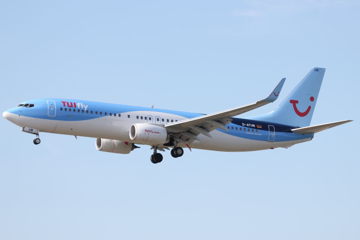 a blue and white airplane flying in the sky