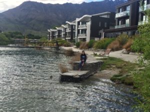 a person sitting on a dock in front of a lake