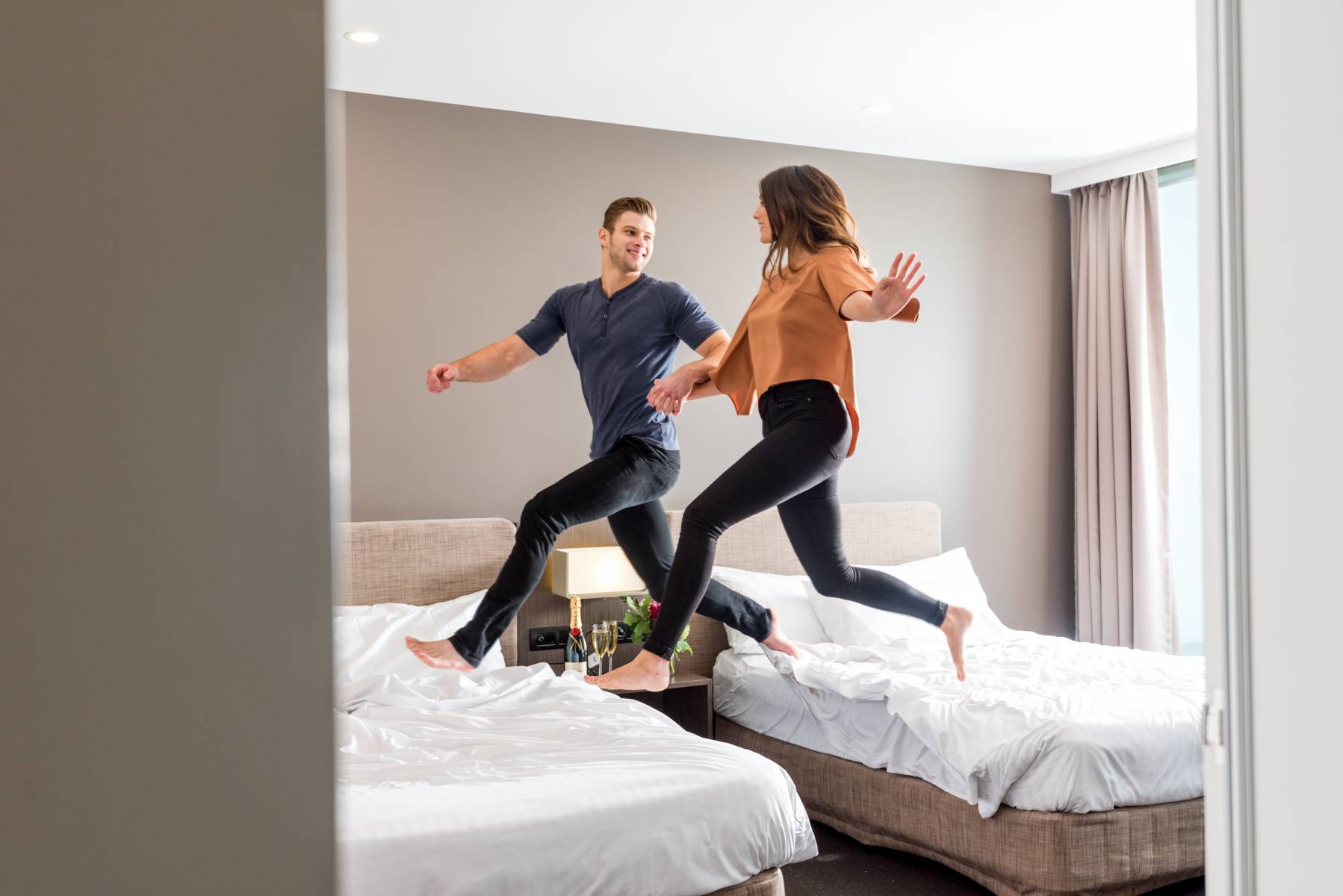 a man and woman jumping on a bed