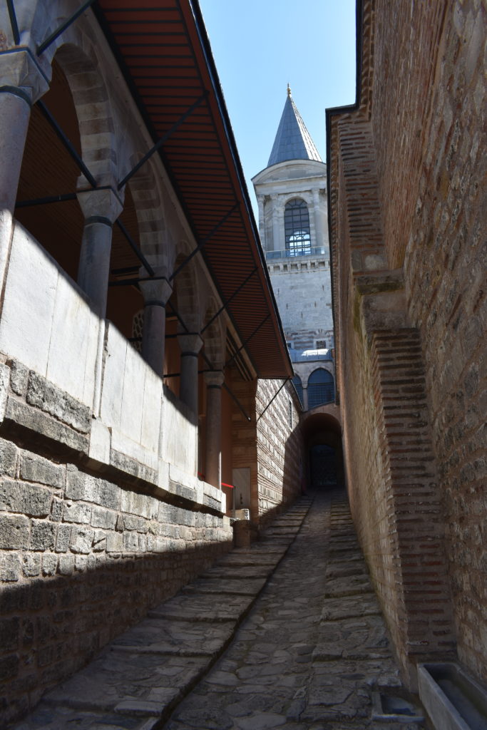 a stone walkway between brick buildings