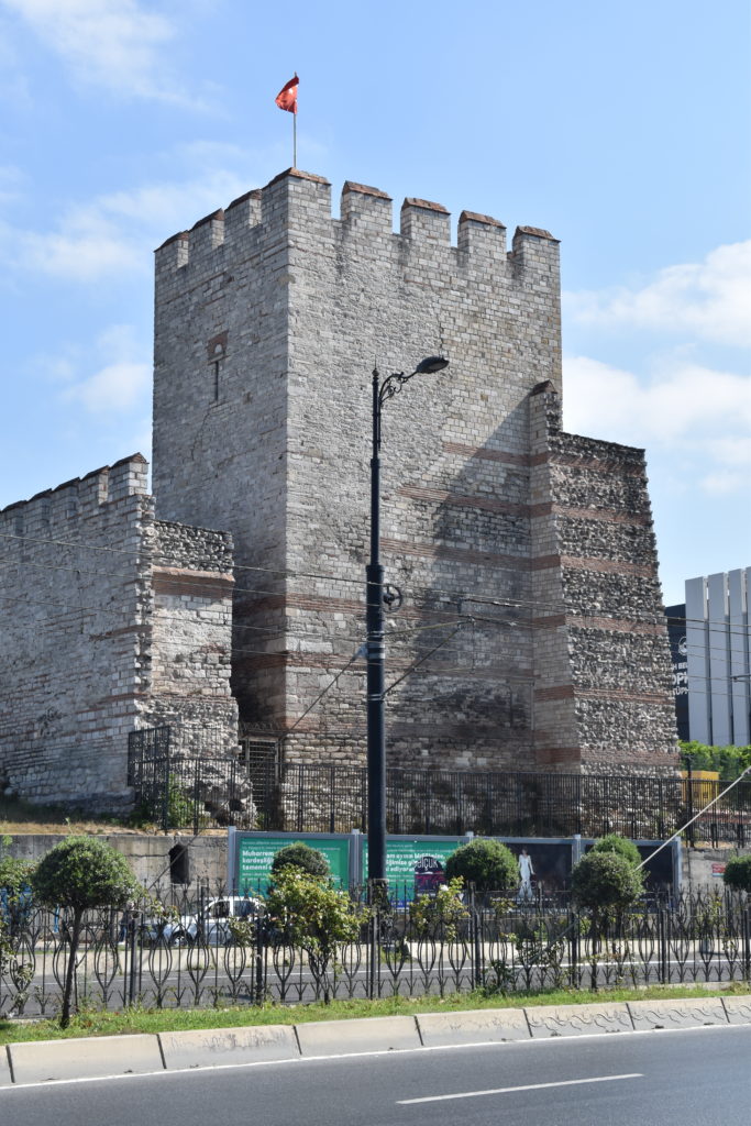 a stone castle with a fence and a street light