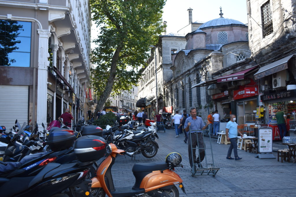 a street with scooters and people walking around