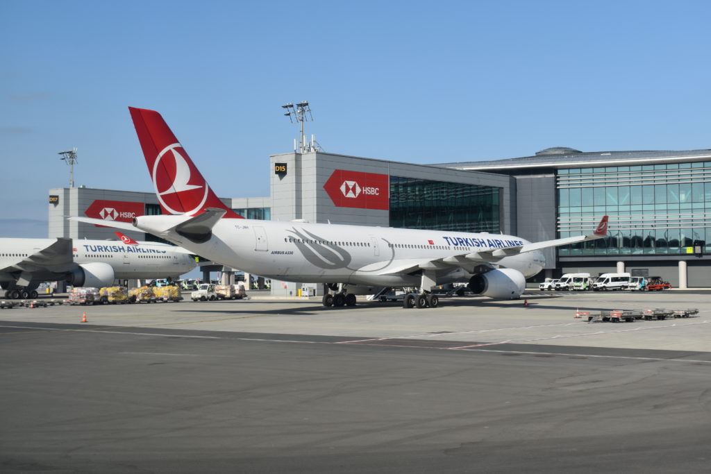 a large white airplane parked in front of a building