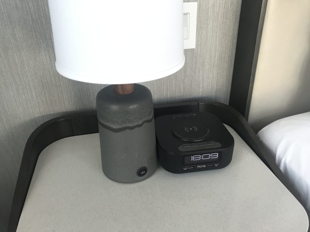 a lamp and alarm clock on a table