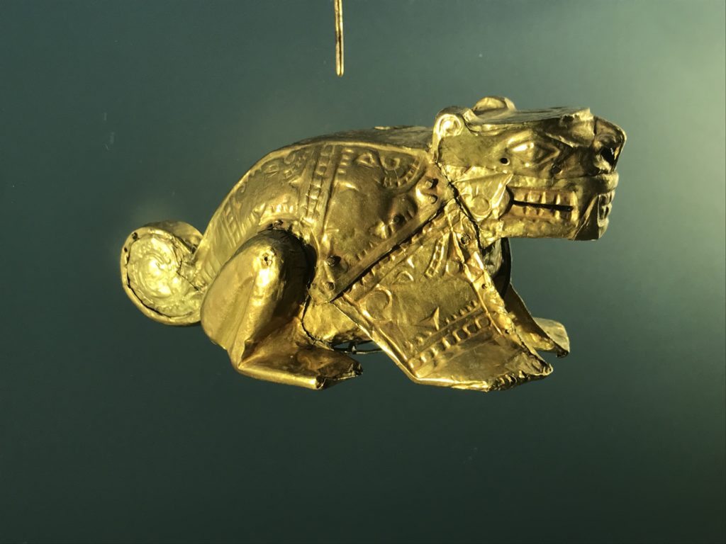 a gold animal statue on a black background
