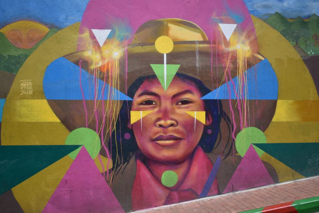 a mural of a woman with colorful triangles and a hat