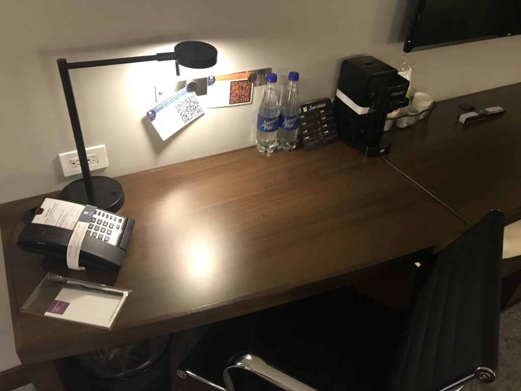 a desk with a phone and water bottles on it