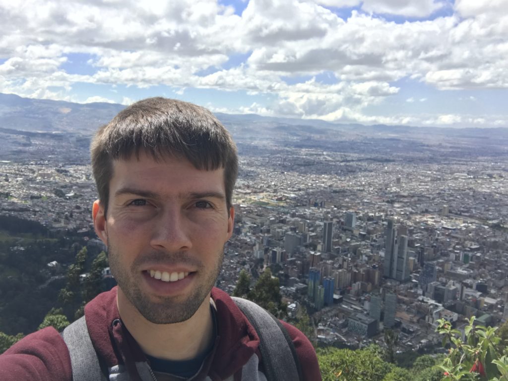 a man taking a selfie with a city in the background