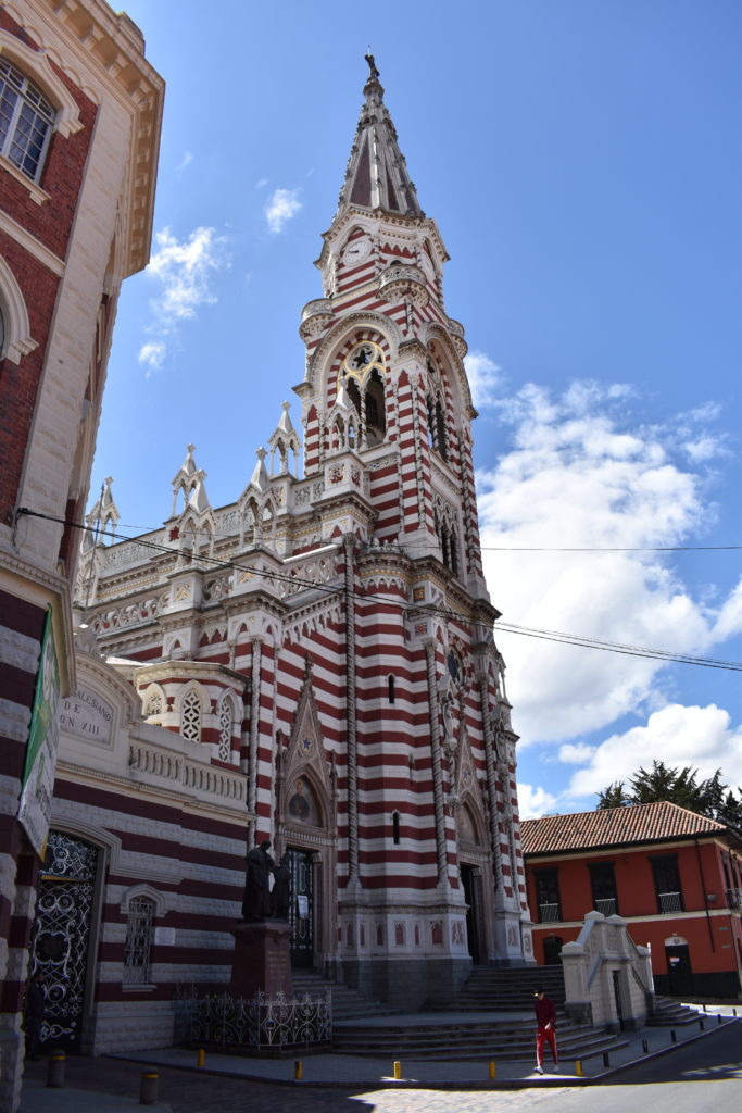 a tall red and white building with a steeple