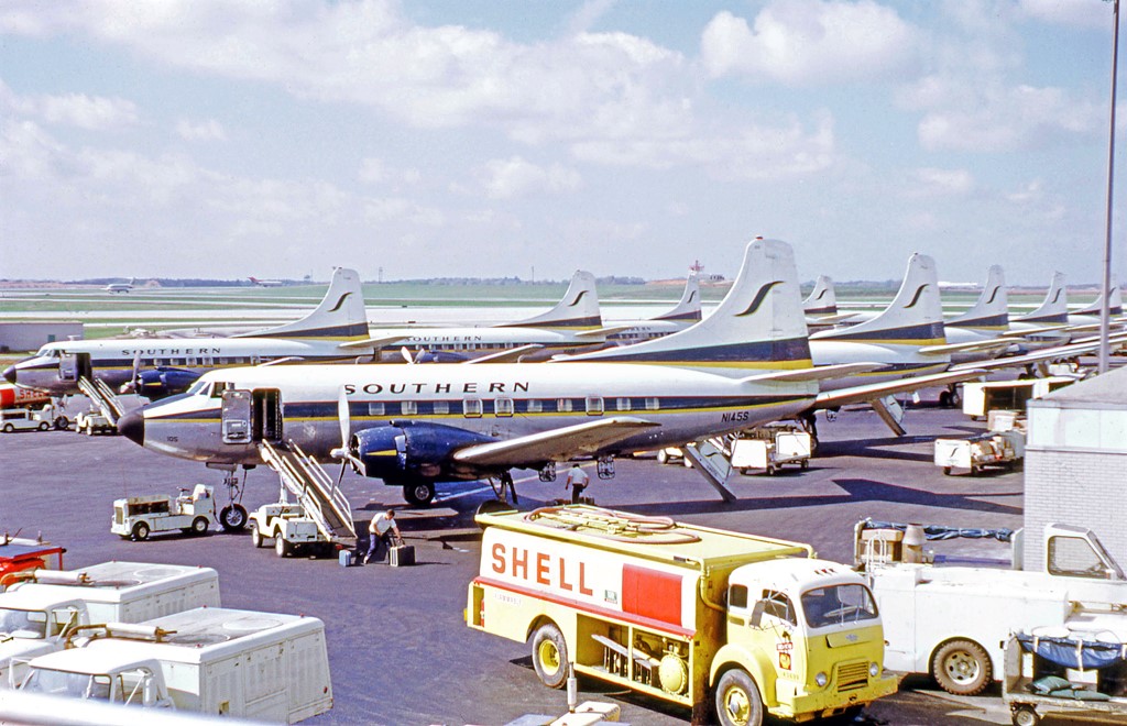 a group of airplanes parked at an airport