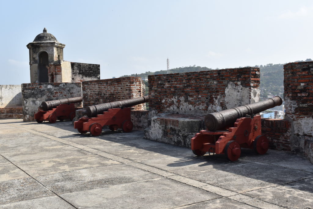 a group of cannons on a brick wall