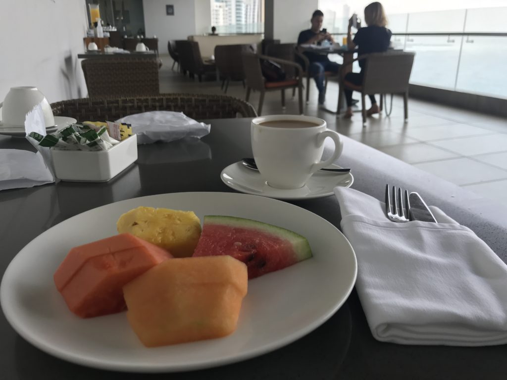 a plate of fruit and a cup of coffee on a table