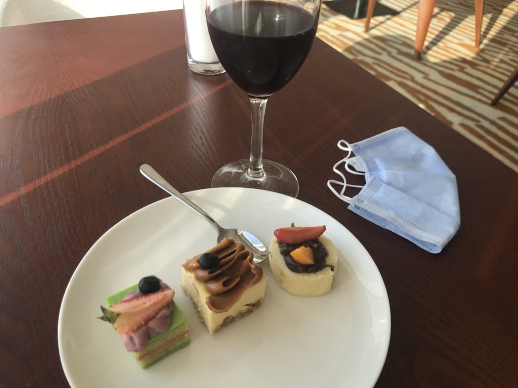 a plate of desserts and a glass of wine