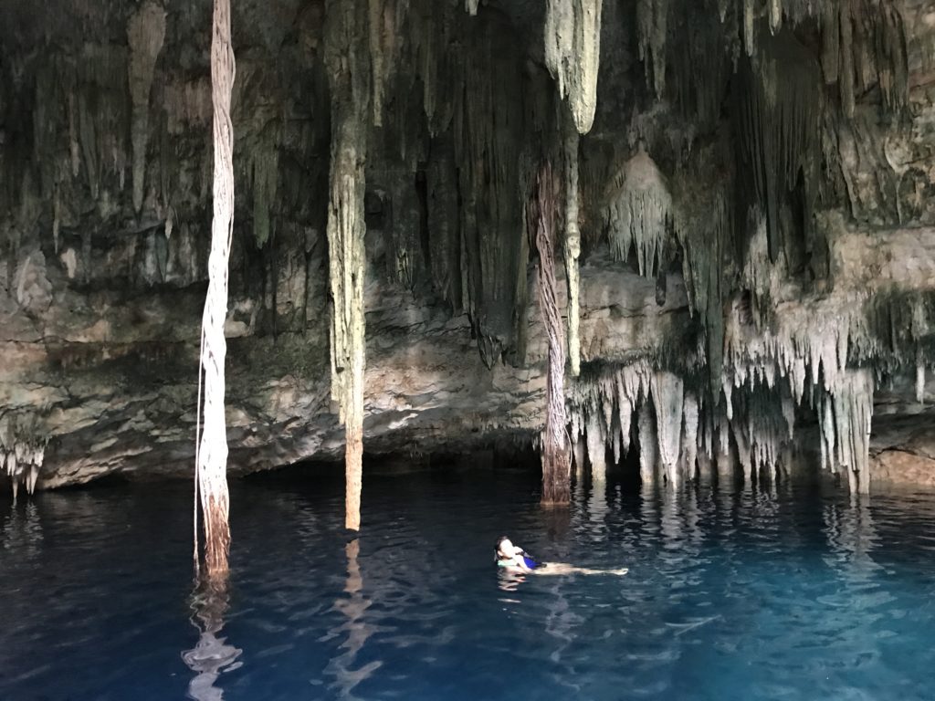 a woman swimming in a cave