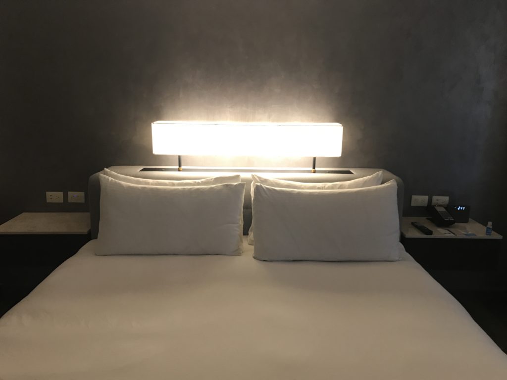 a bed with a lamp above it