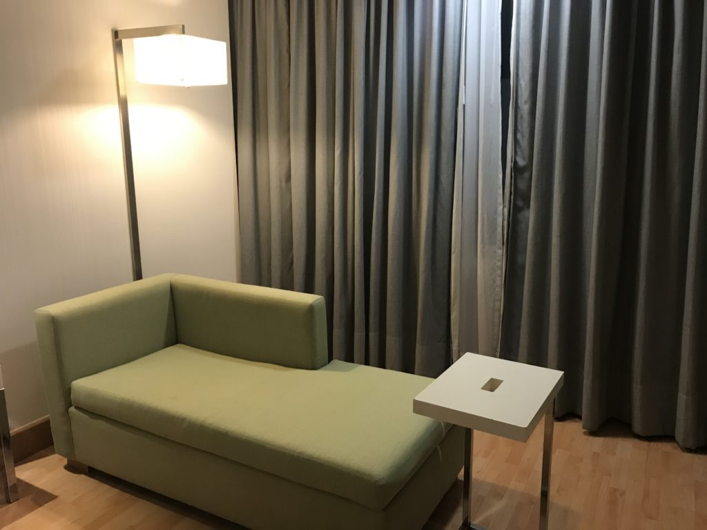 a green couch next to a lamp