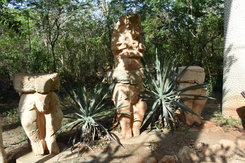 a group of statues in a forest