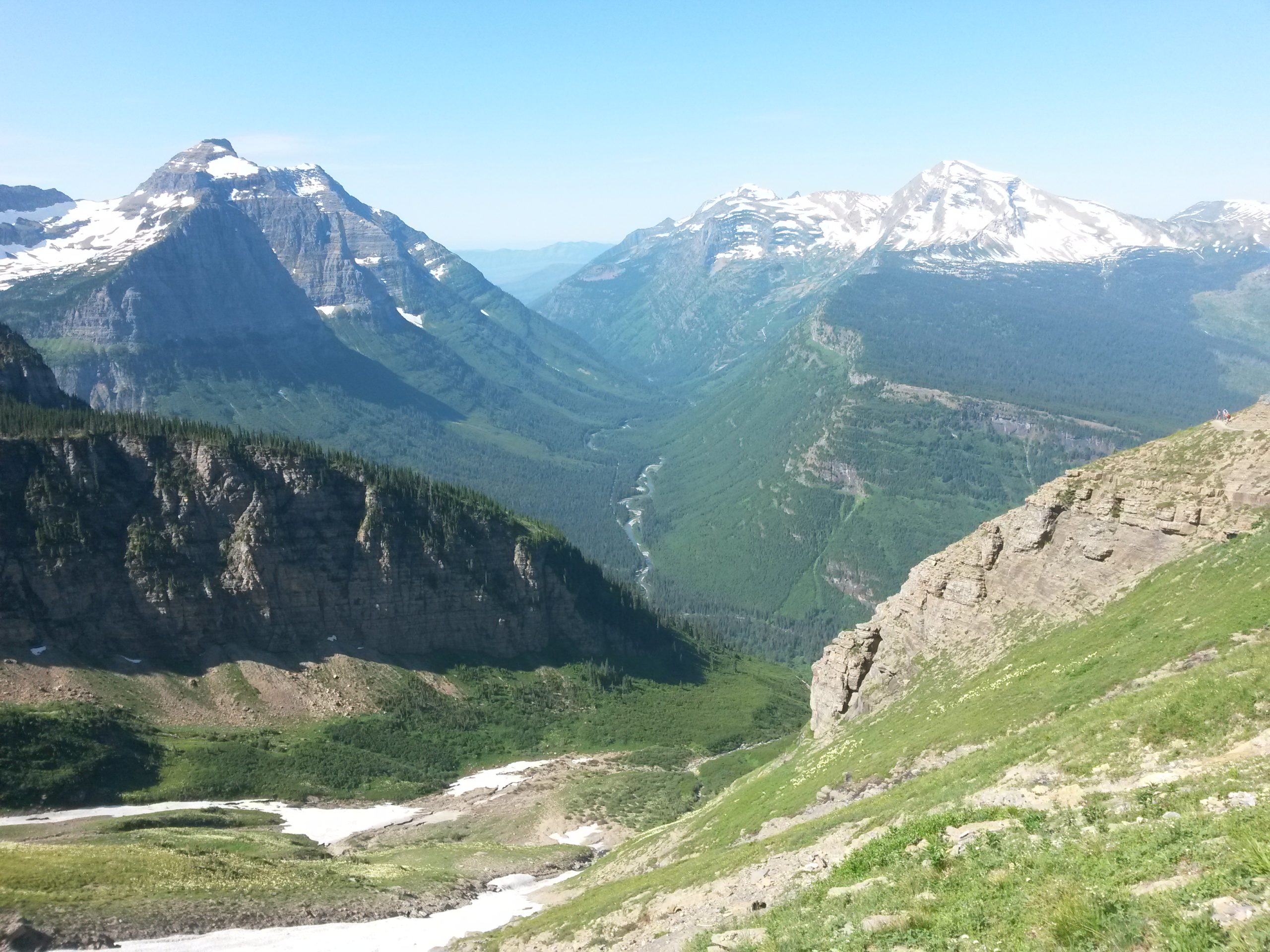 a valley with mountains and snow on the top