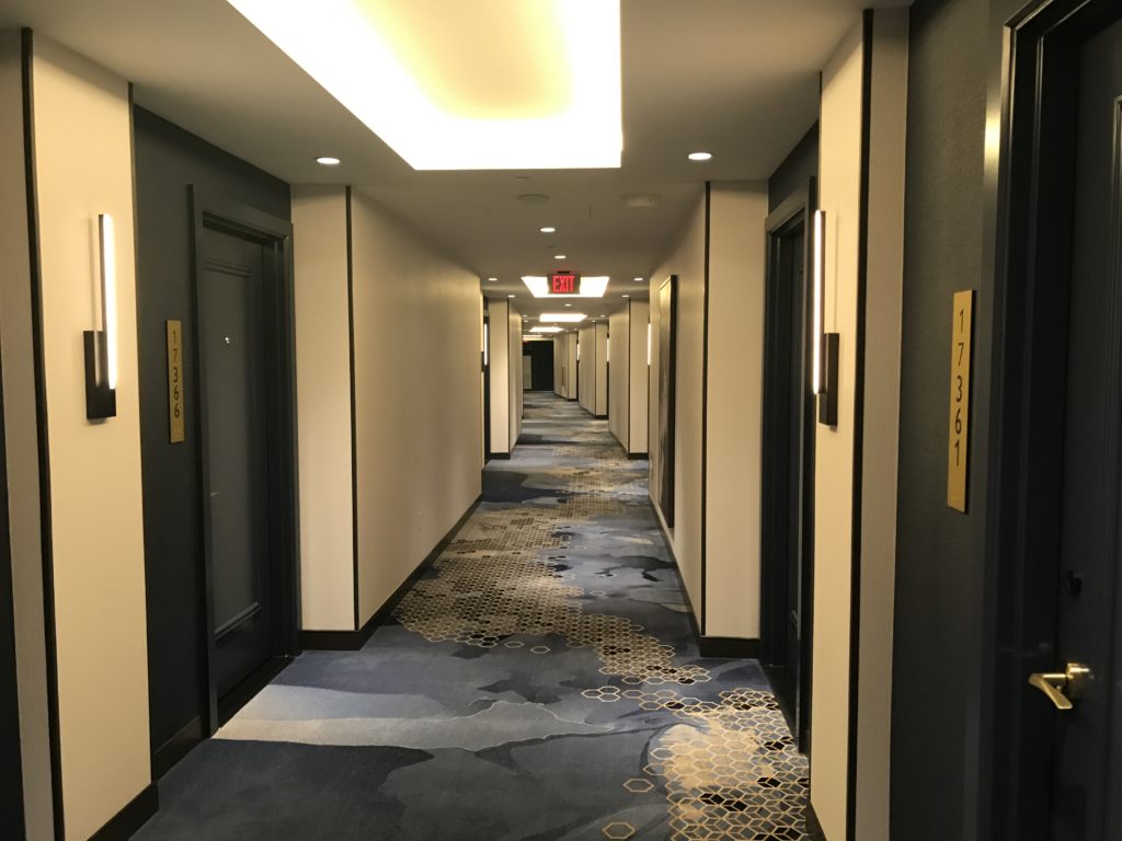a hallway with blue carpet and doors