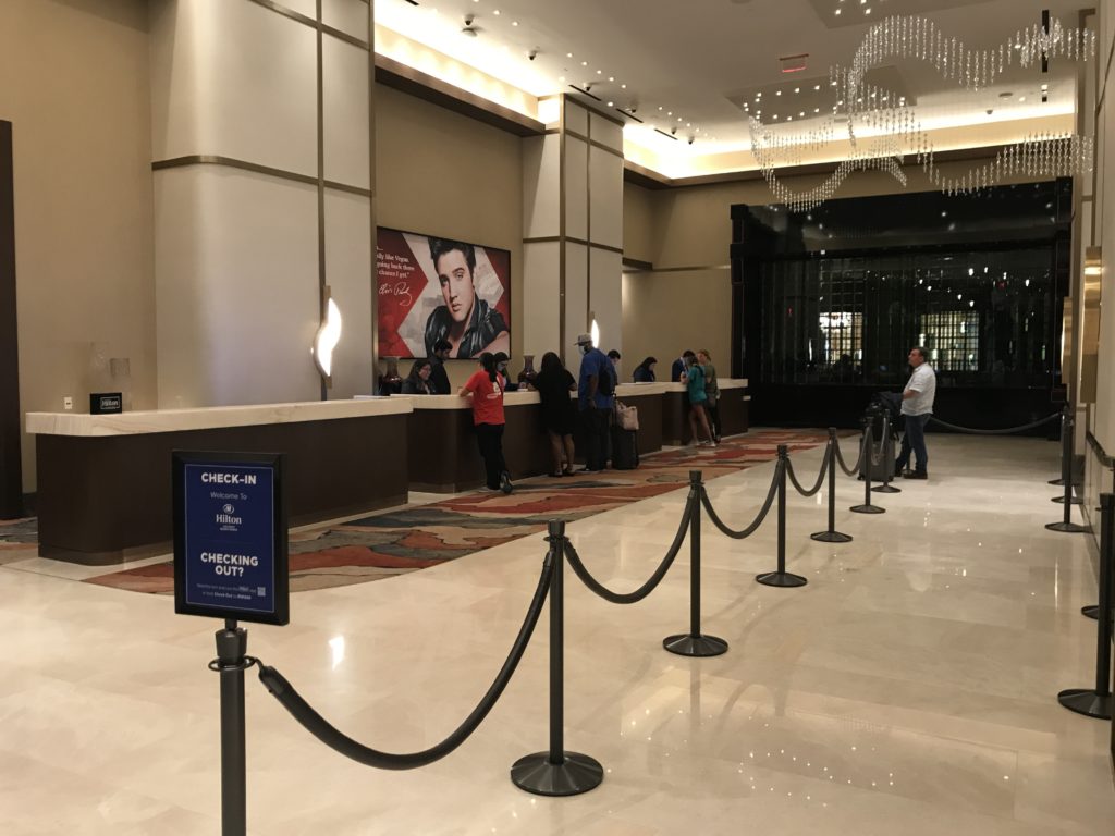 a line of people standing in front of a reception desk