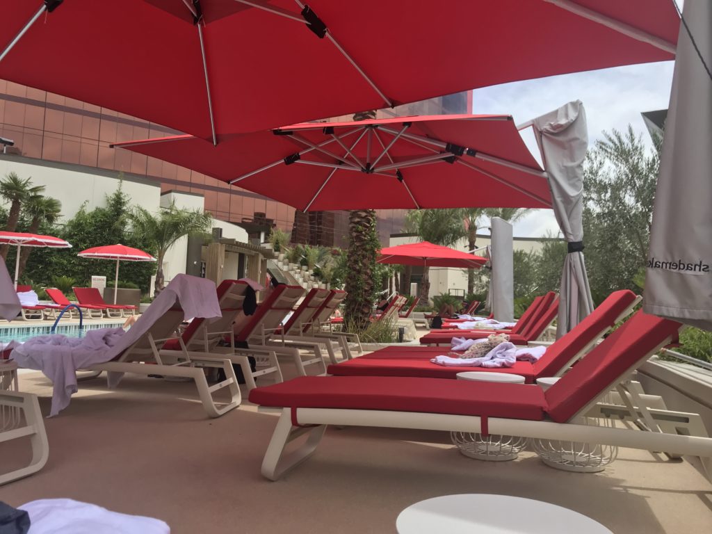 a group of lounge chairs and umbrellas