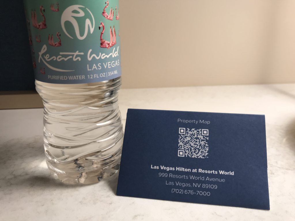 a bottle of water next to a business card