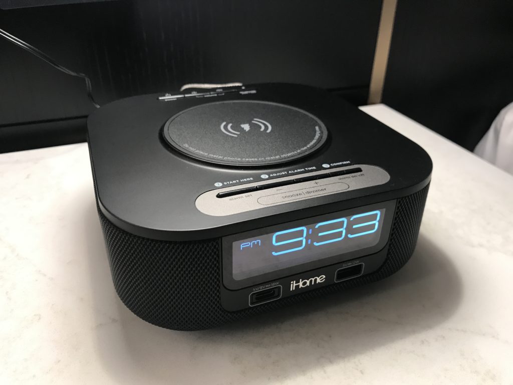 a black alarm clock on a white surface