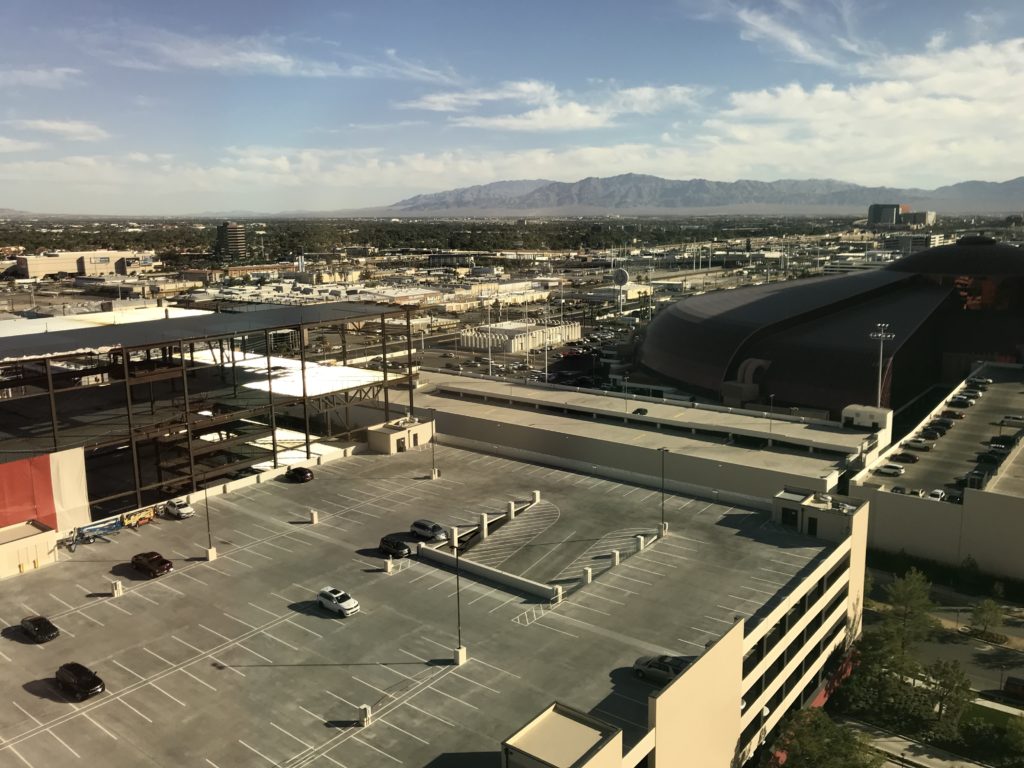 a parking lot with cars and buildings in the background