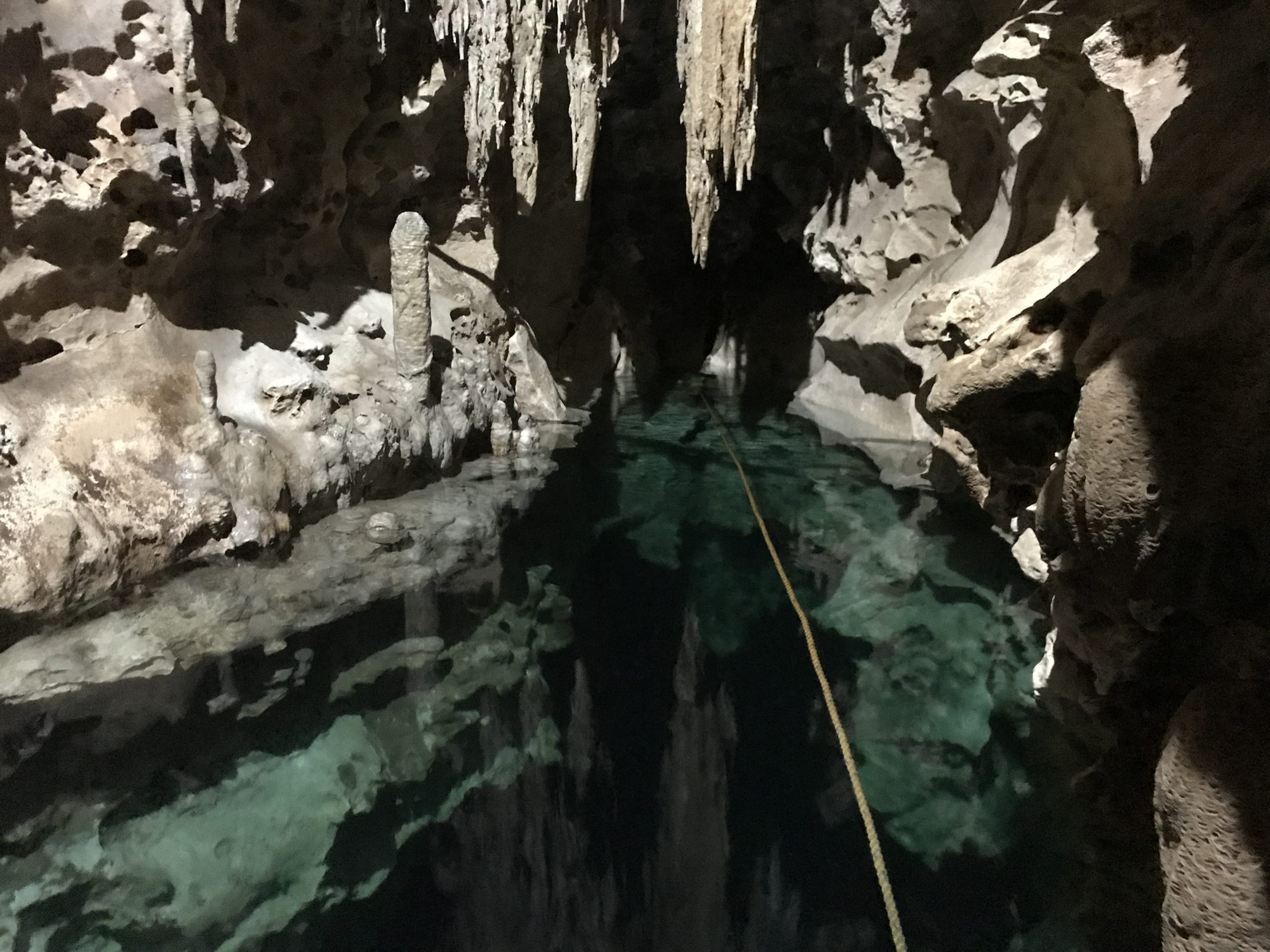 a cave with a clear body of water