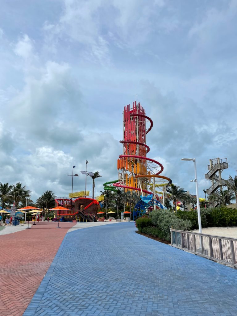a colorful amusement park with a blue walkway and a blue sky