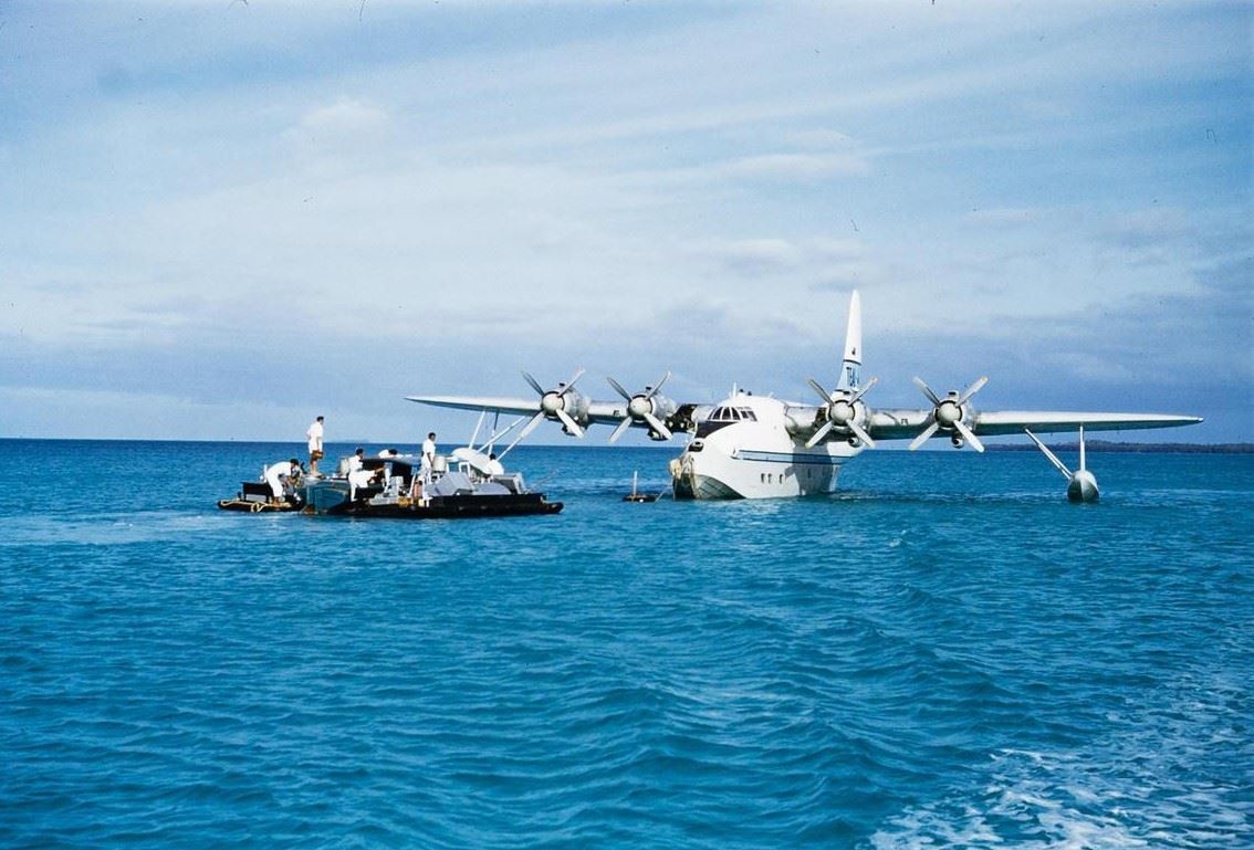 a large white plane on the water