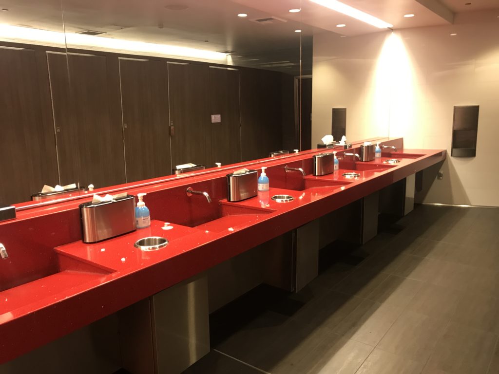 a red bathroom with several sinks
