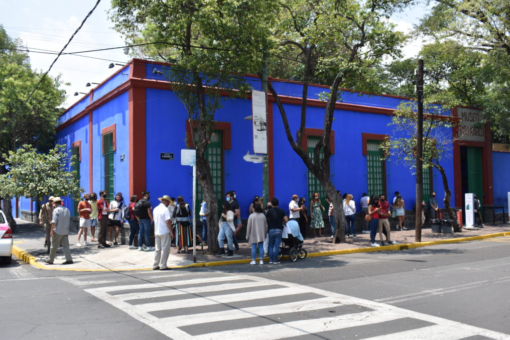 a group of people standing in front of a blue building