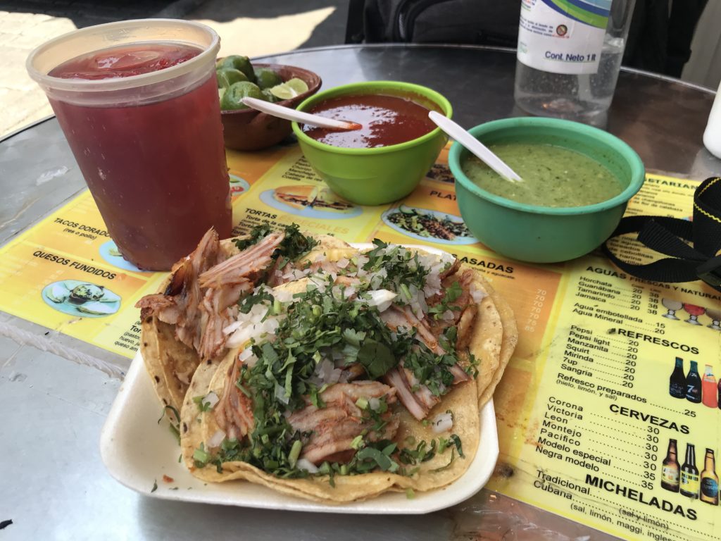 a plate of tacos and sauces on a table