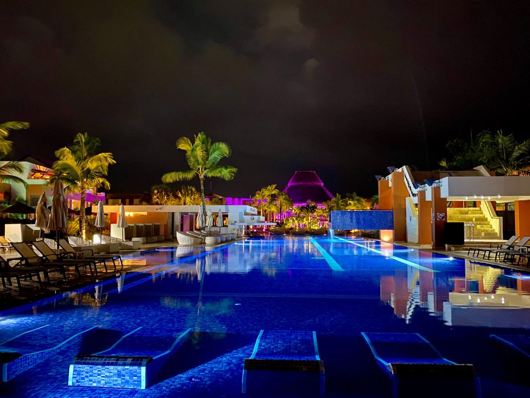 a pool with lights and palm trees