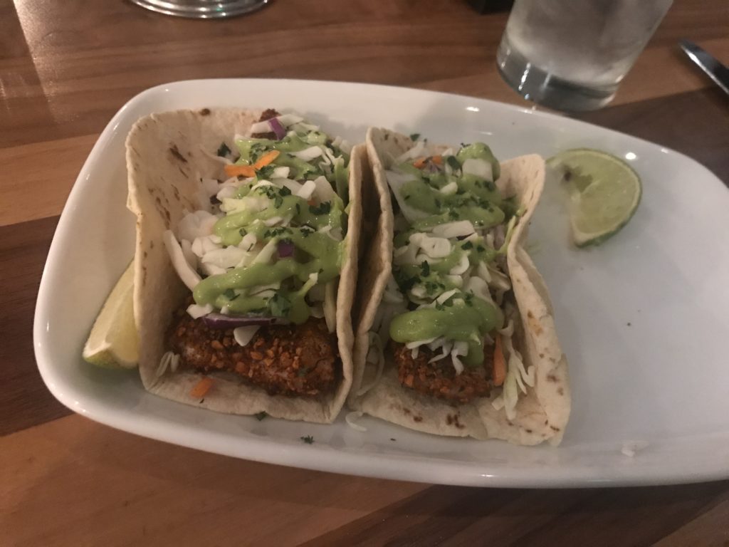 a plate of tacos with sauce and lime