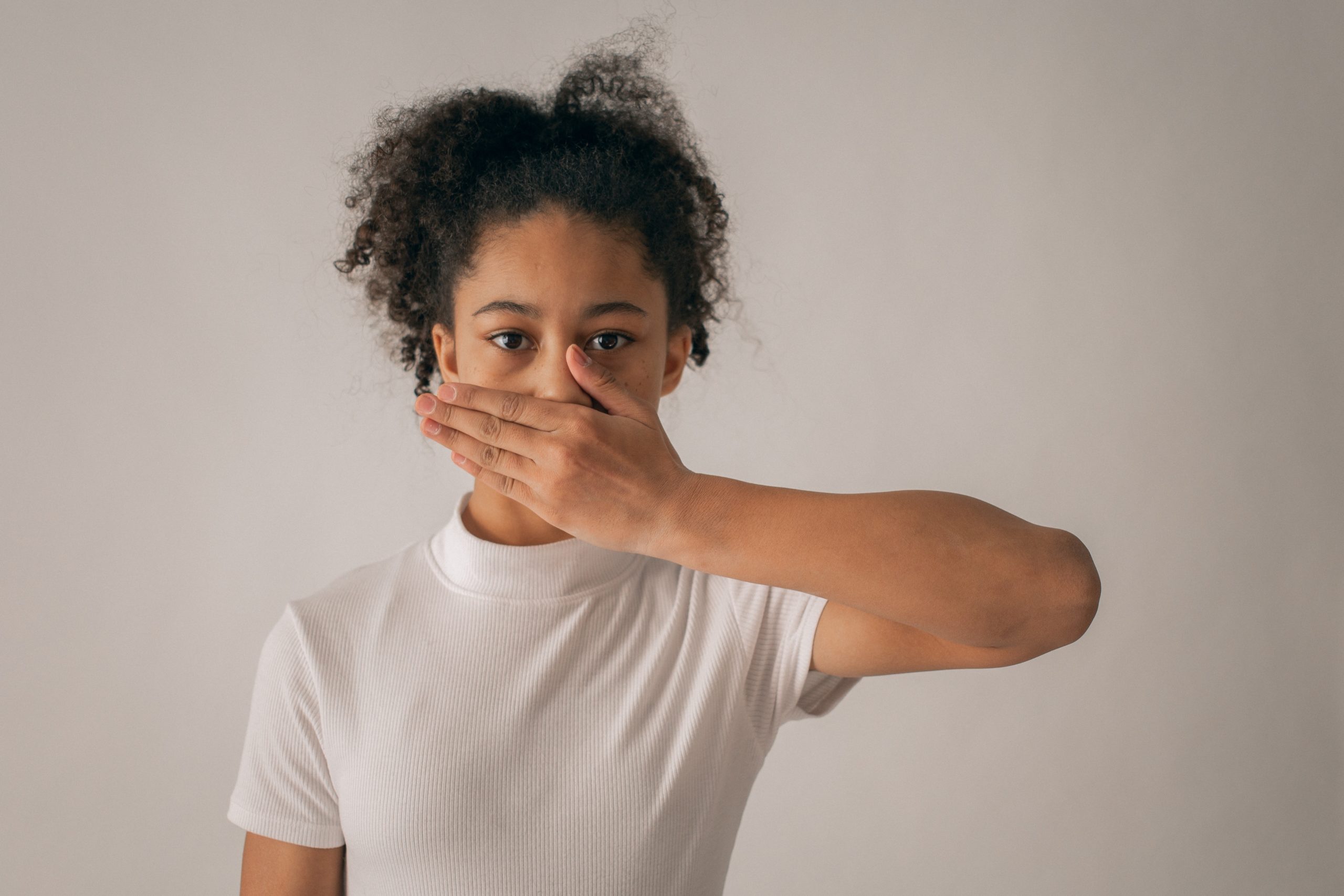 a girl with her hand over her mouth