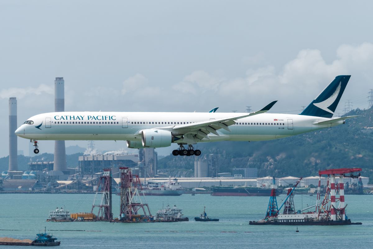 a large white airplane flying over water