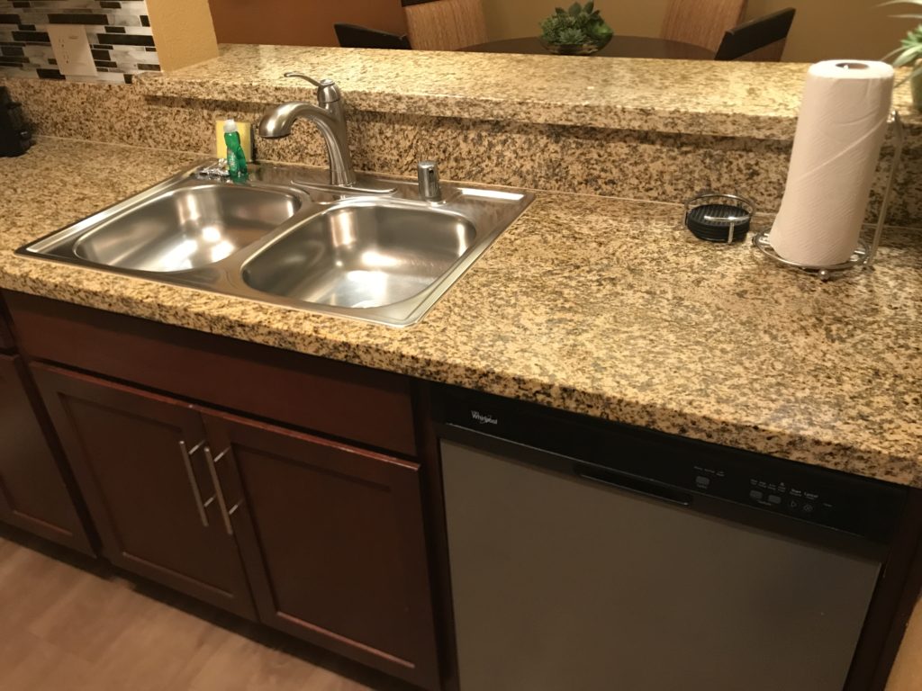 a kitchen counter with a sink and dishwasher