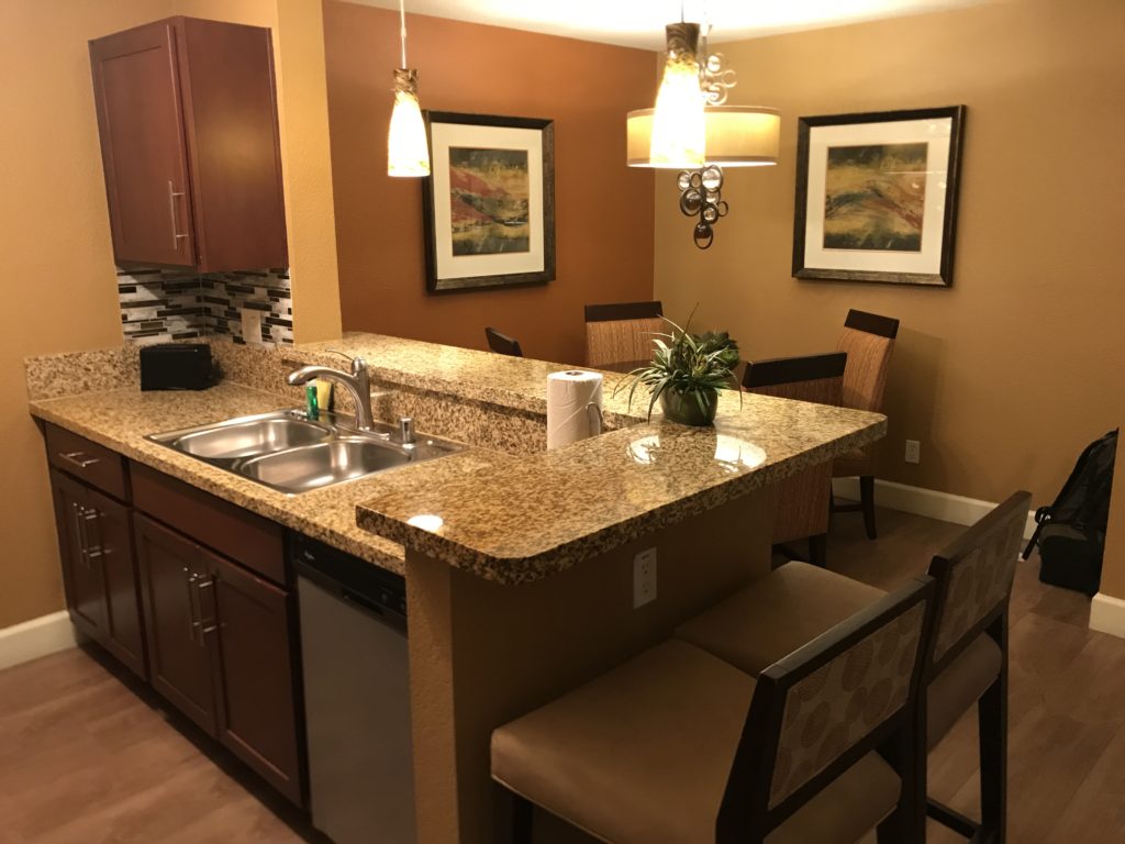 a kitchen with a sink and chairs
