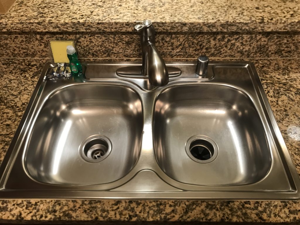 a sink with a faucet and a soap dispenser