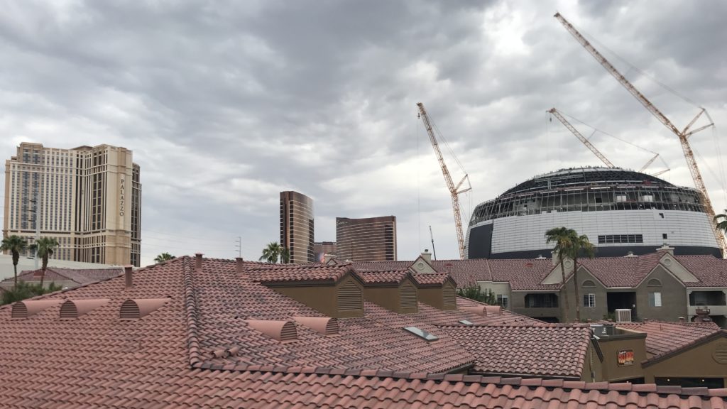 a rooftops of a building with cranes in the background