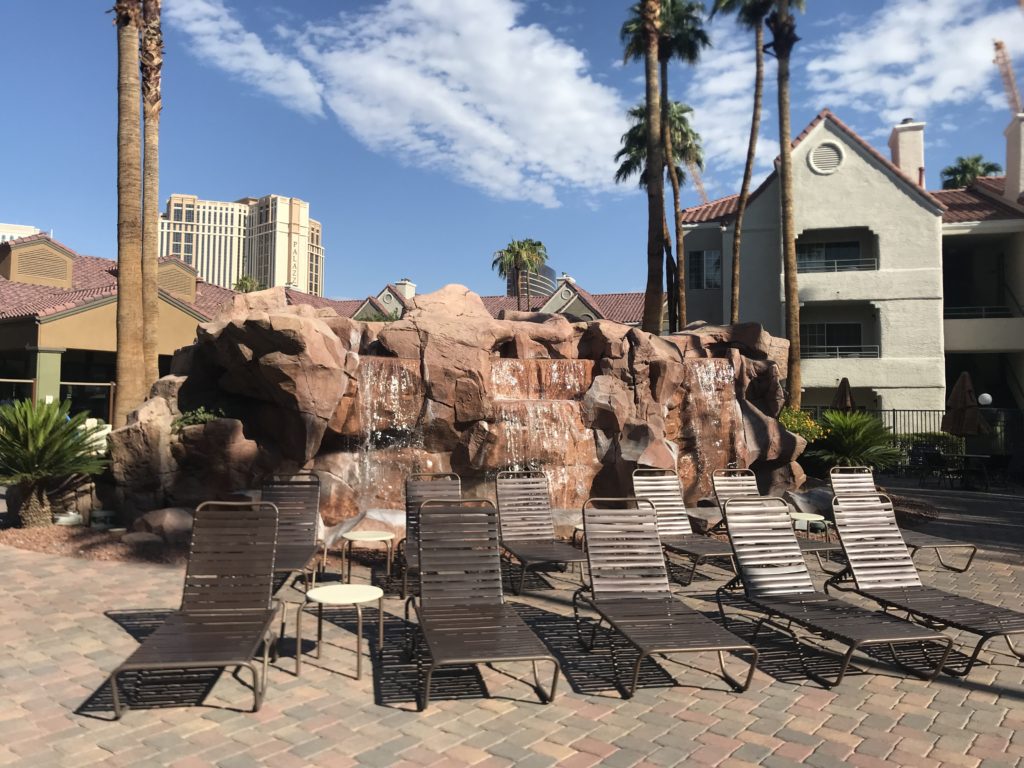 a group of lounge chairs in front of a waterfall