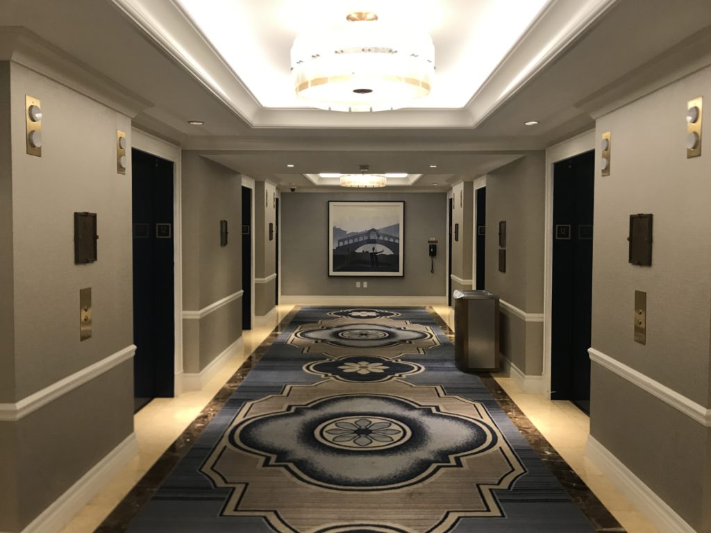 a hallway with a light fixture and a picture on the wall