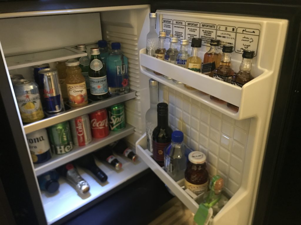 a mini fridge with bottles of alcohol